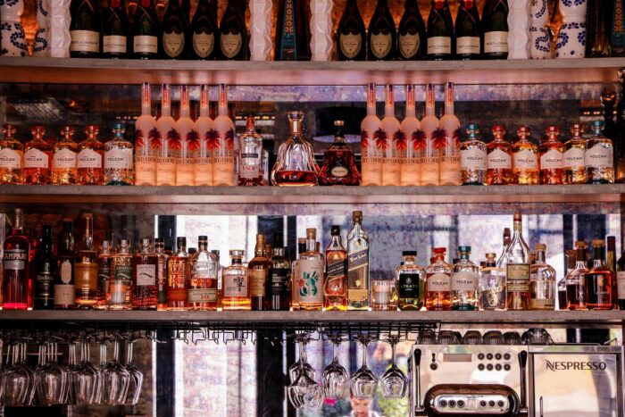 A well-stocked bar display featuring various bottles of liquor and glassware, perfect for nightlife scenes.