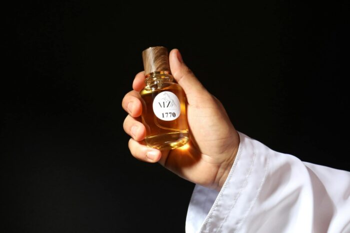 Close-up of a hand holding a luxurious whisky bottle, elegant and sophisticated.