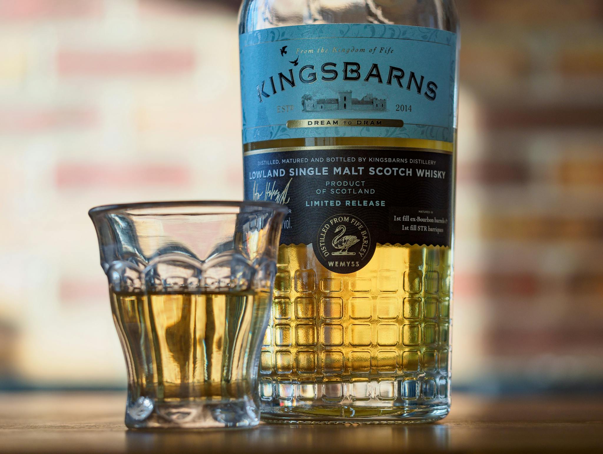 Close-up of Kingsbarns Lowland Single Malt Scotch whisky bottle and glass.