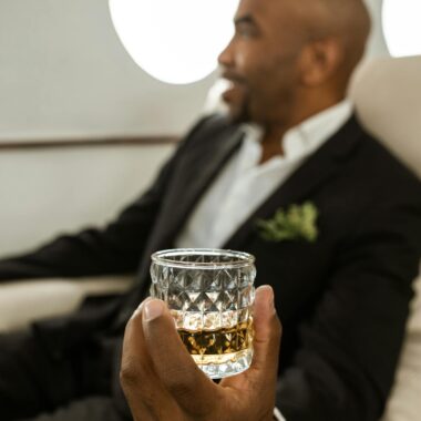 Elegant man enjoying whiskey on a private jet, symbolizing luxury travel and elite lifestyle.