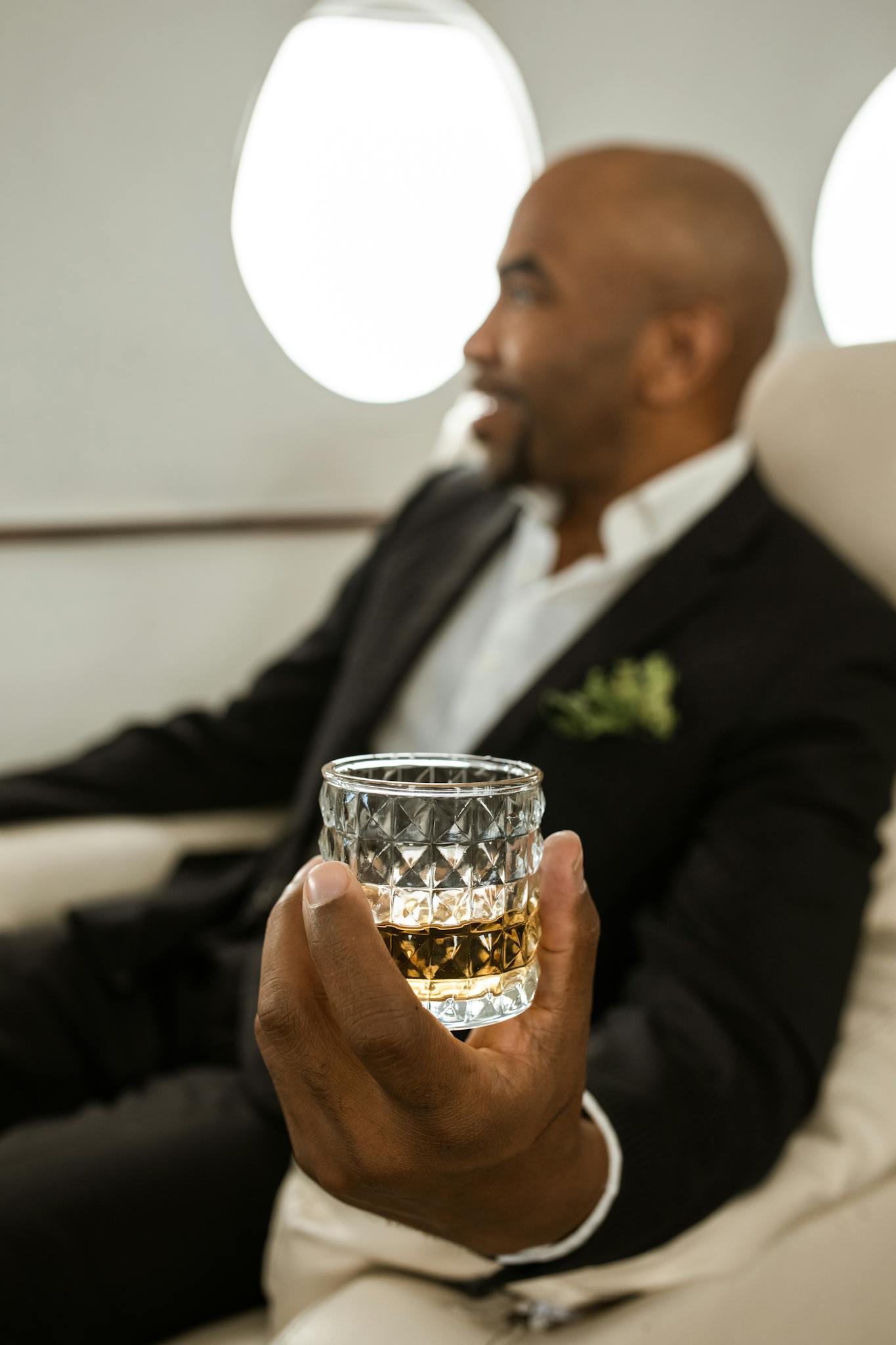 Elegant man enjoying whiskey on a private jet, symbolizing luxury travel and elite lifestyle.